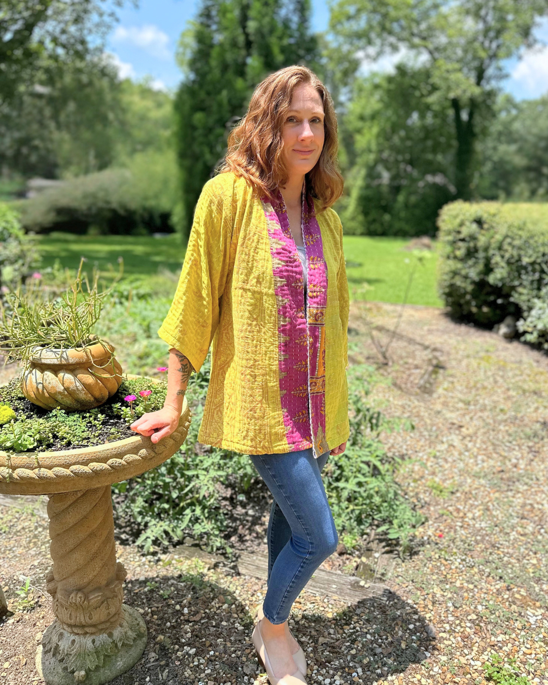 Woman wearing a handcrafted, upcycled Kantha kimono from TheNickStitch, featuring a Citron base with magenta and multicolor patchwork including elephants, made from recycled cotton saris.